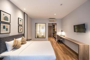 a bedroom with a large bed and a desk at Seava Ho Tram Beach Resort in Ho Coc
