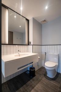 a bathroom with a sink and a toilet and a mirror at Seava Ho Tram Beach Resort in Ho Coc