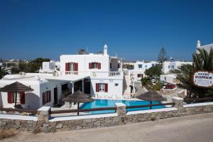 a white house with a swimming pool in front of it at Domna Hotel in Mikonos
