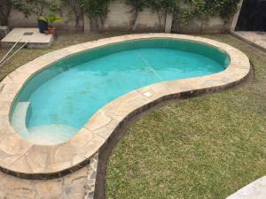 a large swimming pool with a stone retaining wall around it at Villa Sunshine in Ukunda