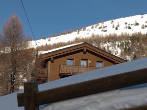 a log cabin with a balcony in the snow at Al Dos in Livigno