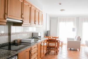 a kitchen with wooden cabinets and a dining room at APARTAMENTS COLELLS in Bordes d´Envalira 
