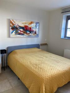 uma cama num quarto com um quadro na parede em phoebus 01 em De Panne