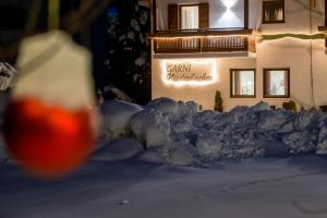 カンポ・トゥーレスにあるGarni Niederbacherの雪の上に看板を載せた建物