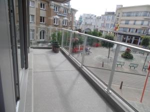 een balkon met uitzicht op een binnenplaats met gebouwen bij phoebus 01 in De Panne