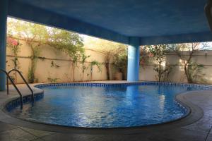 a swimming pool in a building with blue columns at Gulf Delmon in Dammam