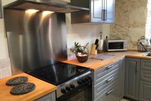 a kitchen with a stainless steel stove top oven at Beautiful Eymet Bastide house & courtyard garden in Eymet