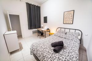 een slaapkamer met een bed met een zwart-wit dekbed bij LGC Habitat- chambre privée- appartement commun- gare Saint-Roch in Montpellier