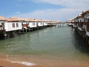 una fila de casas en el agua junto a los edificios en Wonderland Private Pool Villas at Port Dickson en Port Dickson