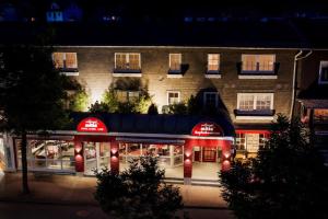 a building with a restaurant in front of it at night at Hotel Willinger Mitte in Willingen