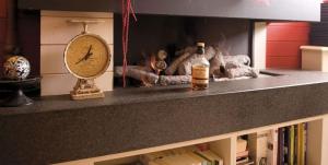 a clock and a bottle on a shelf with books at Hotel Internos in De Haan