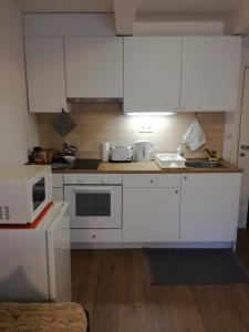 uma cozinha com armários brancos e um micro-ondas em Malý útulný byt V Lipkách em Hradec Králové