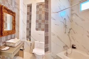 a bathroom with a tub and a toilet and a sink at Baroque Boutique Resort in Ranong