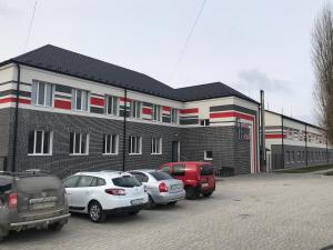 a building with cars parked in a parking lot at Good Rest in Chemerivtsi