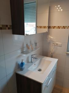 La salle de bains est pourvue d'un lavabo et d'un miroir. dans l'établissement Hotel-Restaurant Zum Bäumle, à Süßen