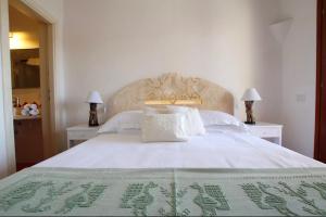 a bedroom with a large white bed with two lamps at Welcomely - Porto Cervo sul Mare in Porto Cervo