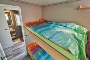 a bed with a colorful comforter in a room at Floating house BRAVIA in Portorož