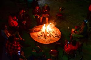 a group of people sitting around a fire at Dovenest Lodge in Naivasha