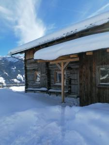 a log cabin with snow on the roof at Ferienhütte Georg in Hippach