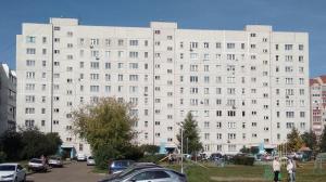 ナーベレジヌイェ・チェルヌイにあるApartment on Kol Galiの駐車場車を停めた白い大きな建物