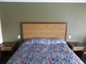 a bedroom with a bed with two nightstands and two tables at National Inn Garden Grove in Anaheim