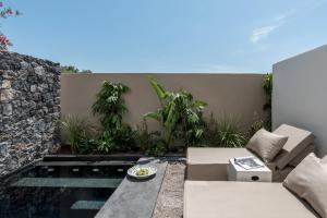 a patio with a couch and some plants at Istoria, a Member of Design Hotels in Perivolos