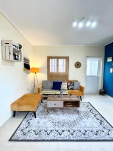 a living room with a couch and a table at Boho Apartment near Athens Airport in Spáta