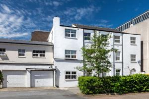 a white building with a garage in front of it at The Harrogate Penthouse in Harrogate