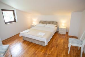 a bedroom with a bed with two lamps and a chair at House Emilija in Novalja