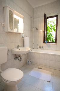 a bathroom with a toilet and a sink and a tub at House Emilija in Novalja +25 photos