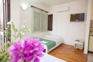a hotel room with a bed and a tv at House Emilija in Novalja