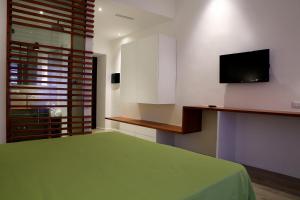a bedroom with a green bed and a flat screen tv at Why Not Roma Suite in Rome