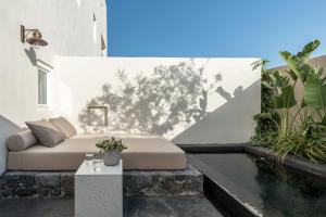 a bedroom with a bed and a swimming pool at Istoria, a Member of Design Hotels in Perivolos