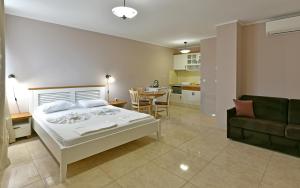 a bedroom with a bed and a couch and a table at Sirena Palace Family Hotel in Obzor +37 photos