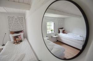 a mirror reflection of a bedroom with two beds at 4B Österlen Bed & Breakfast in Tomelilla