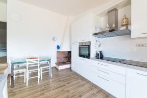 a kitchen with white cabinets and a dining table at VILLA ALOE in Costa Paradiso +7 photos