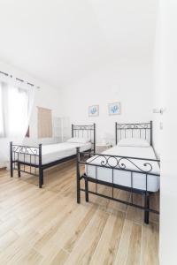 two beds in a room with a wooden floor at VILLA ALOE in Costa Paradiso