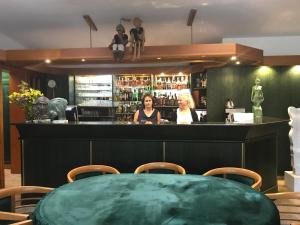 two women standing at the bar in a restaurant at Antik Hotel Sofia in Litomyšl