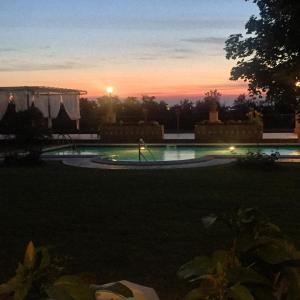 una puesta de sol sobre una piscina en un patio en Agriturismo Corte Bebbi, en Bibbiano