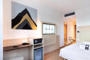 a bedroom with a bed and a tv on a wall at B&B Hotel Bolzano in Bolzano