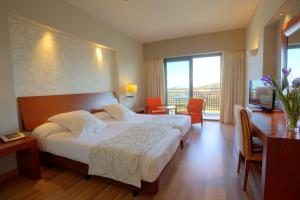ベラにあるValle Del Este Golf Resortのベッドと大きな窓が備わるホテルルームです。