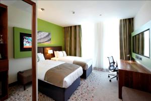 a hotel room with two beds and a television at Holiday Inn Bristol City Centre, an IHG Hotel in Bristol