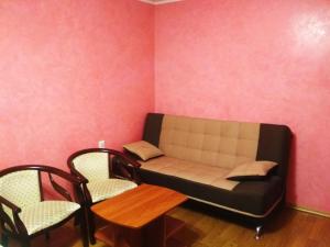 a couch in a room with two chairs and a table at Prime Home in Chernihiv