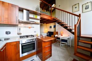 une cuisine avec des placards en bois et un escalier avec une table dans l'établissement UR-NEST Beverara, à Bologne