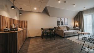 a living room with a couch and a table at Lake Hill Karkonosze Apartments in Sosnówka