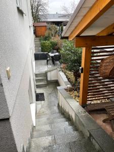 un pequeño patio con una mesa y escaleras junto a un edificio en Ferienwohnung Casa Mia, en Leimen