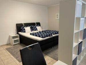 a bedroom with a bed with a black headboard at Ferienwohnung Casa Mia in Leimen