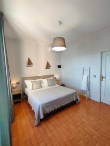 a bedroom with a large white bed and a ladder at Albergo La Pescatrice in Moniga