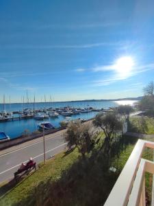 duas pessoas sentadas num banco com vista para uma marina em Albergo La Pescatrice em Moniga