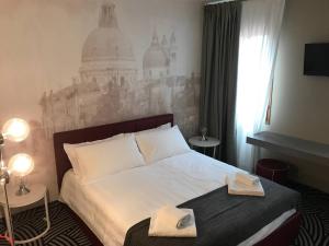 a bedroom with a bed with two towels on it at Hotel Cannaregio 2357 in Venice